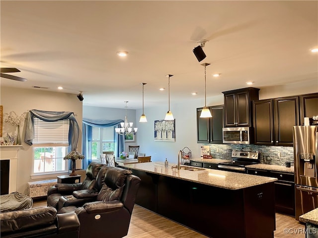 15518 Centerline Ct, Chesterfield, VA 23832 - kitchen featuring appliances with stainless steel finishes, open floor plan, light stone counters, a chandelier, and recessed lighting