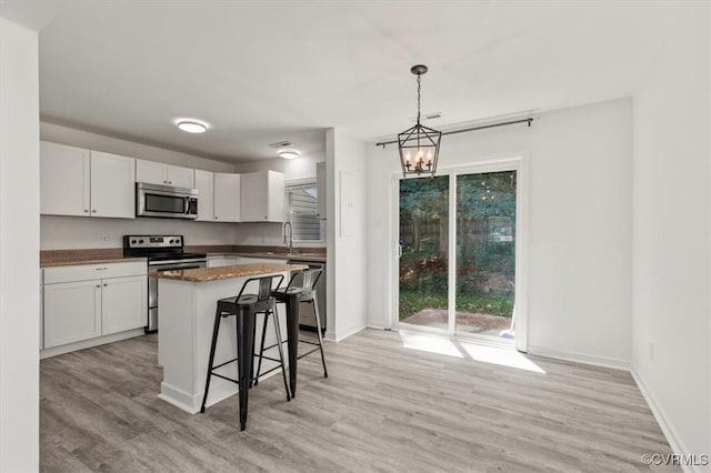 15241 Broadwater Cir, Chesterfield, VA 23831 - kitchen featuring stainless steel appliances, light wood-style flooring, white cabinetry, and a kitchen bar