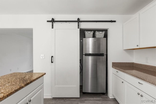 15241 Broadwater Cir, Chesterfield, VA 23831 - kitchen featuring freestanding refrigerator, dark wood-type flooring, dark stone counters, white cabinetry, and a barn door