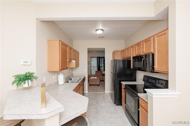 405 Hollybrook Ridge Ln, Richmond, VA 23223 - kitchen featuring black appliances, light countertops, a peninsula, light brown cabinetry, and a kitchen breakfast bar