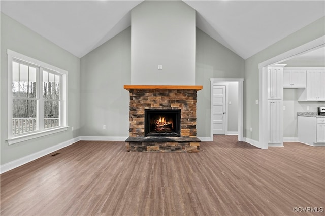 4858 Powhatan Lakes Rd, Powhatan, VA 23139 - unfurnished living room featuring a stone fireplace, wood finished floors, and high vaulted ceiling
