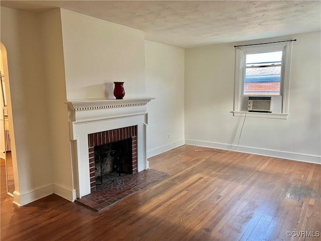 3305 Jeter Ave, Richmond, VA 23222 - unfurnished living room featuring hardwood / wood-style flooring, a brick fireplace, arched walkways, and cooling unit