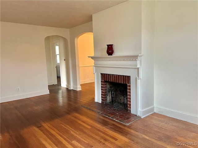 3305 Jeter Ave, Richmond, VA 23222 - unfurnished living room featuring wood finished floors, a fireplace, and arched walkways