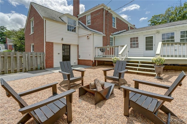 4824 Coleman Rd, Richmond, VA 23230 - back of property featuring a fire pit, a wooden deck, and brick siding