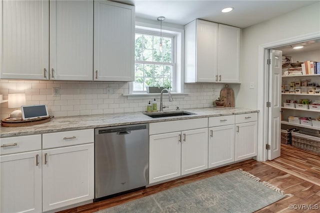 4824 Coleman Rd, Richmond, VA 23230 - kitchen with stainless steel dishwasher, white cabinets, light wood-style flooring, decorative backsplash, and light stone countertops