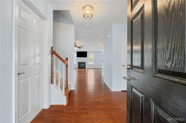 3316 Kennington Park Rd, King William, VA 23009 - foyer entrance featuring dark wood-style flooring, stairs, a ceiling fan, and a glass covered fireplace