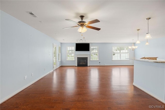 3316 Kennington Park Rd, King William, VA 23009 - unfurnished living room with wood finished floors, a glass covered fireplace, a chandelier, and a ceiling fan