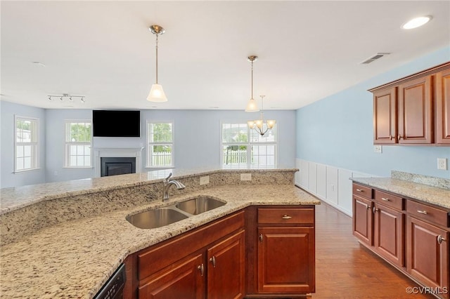 3316 Kennington Park Rd, King William, VA 23009 - kitchen featuring dark wood finished floors, light stone counters, a chandelier, a glass covered fireplace, and decorative light fixtures