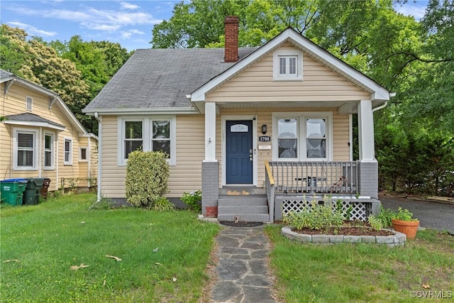 1708 Westwood Ave, Richmond, VA 23227 - bungalow-style house featuring covered porch, a chimney, a front yard, and roof with shingles