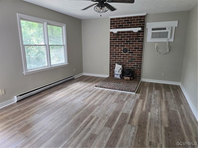 4562 Woodview Dr, Sandston, VA 23150 - unfurnished living room with a baseboard radiator, a wall mounted AC, a ceiling fan, wood finished floors, and a wood stove
