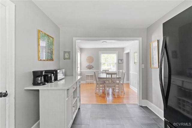 1012 Ridgecliff Dr, Richmond, VA 23224 - kitchen featuring freestanding refrigerator, white cabinets, light countertops, and tile patterned floors