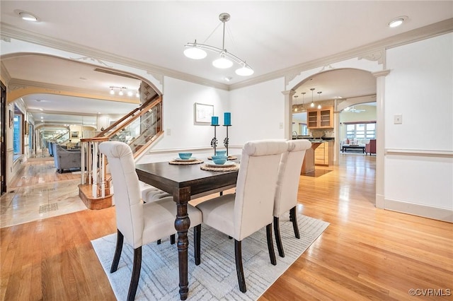 2821 Newquay Ln, North Chesterfield, VA 23236 - dining room with arched walkways, crown molding, decorative columns, light wood-type flooring, and stairway