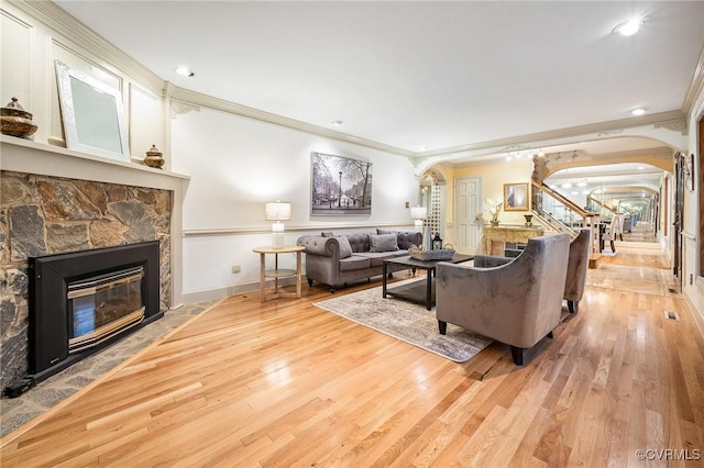 2821 Newquay Ln, North Chesterfield, VA 23236 - living room with arched walkways, ornamental molding, a stone fireplace, stairs, and light wood finished floors