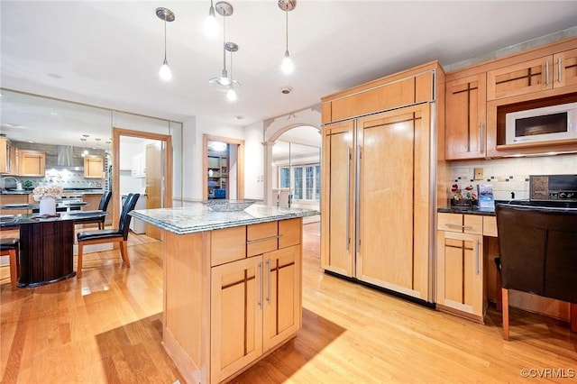 2821 Newquay Ln, North Chesterfield, VA 23236 - kitchen featuring built in appliances, wall chimney range hood, light wood finished floors, backsplash, and a center island