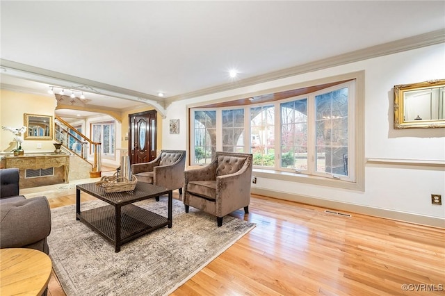 2821 Newquay Ln, North Chesterfield, VA 23236 - living room with arched walkways, ornamental molding, light wood finished floors, and stairs