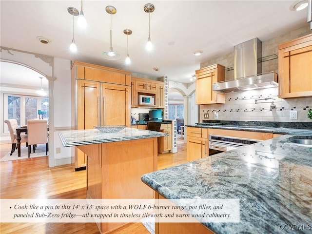 2821 Newquay Ln, North Chesterfield, VA 23236 - kitchen featuring wall chimney range hood, built in appliances, arched walkways, and light wood-type flooring