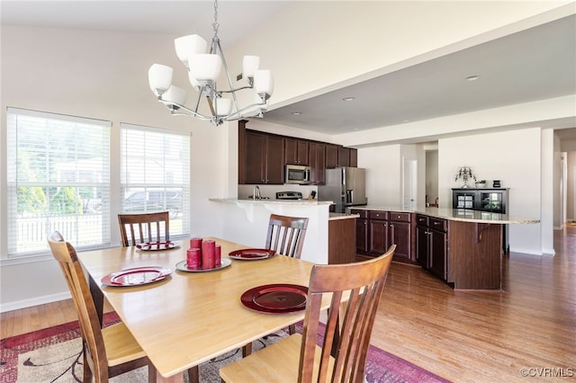 11012 Wingstem Ct, Glen Allen, VA 23060 - dining area featuring wood finished floors, a chandelier, healthy amount of natural light, and high vaulted ceiling