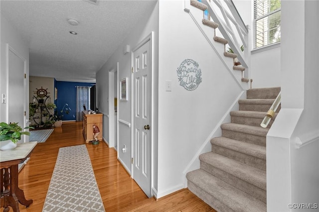 4855 Cypress Point Cir Unit 104, Virginia Beach, VA 23455 - foyer entrance featuring stairway, light wood-type flooring, and a textured ceiling