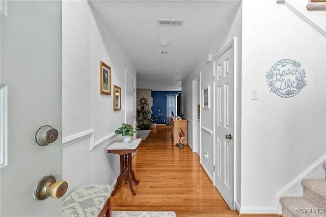 4855 Cypress Point Cir Unit 104, Virginia Beach, VA 23455 - hall featuring light wood-style floors, stairway, and a textured ceiling