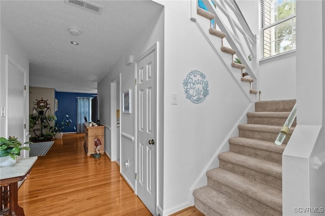 4855 Cypress Point Cir Unit 104, Virginia Beach, VA 23455 - staircase featuring wood finished floors and a textured ceiling