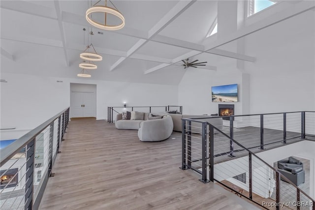 3315 Windmill Point Rd, White Stone, VA 22578 - living area featuring a lit fireplace, a towering ceiling, a ceiling fan, wood finished floors, and beam ceiling