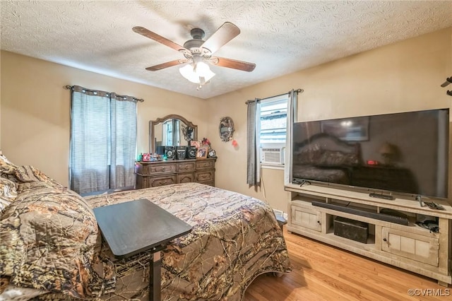 1305 Pea Ridge Rd, King & Queen, VA 23023 - bedroom featuring wood finished floors, a textured ceiling, cooling unit, and a ceiling fan