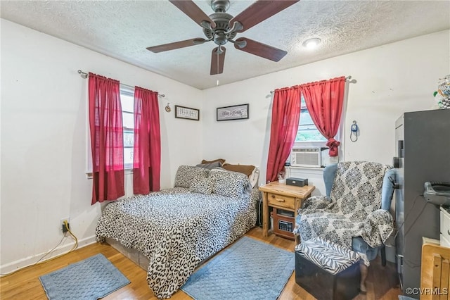 1305 Pea Ridge Rd, King & Queen, VA 23023 - bedroom featuring wood finished floors, a textured ceiling, a ceiling fan, and cooling unit