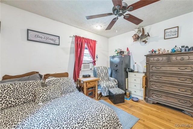 1305 Pea Ridge Rd, King & Queen, VA 23023 - bedroom featuring a textured ceiling, cooling unit, light wood-type flooring, and a ceiling fan