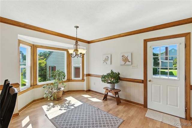 8346 Hanover Grove Blvd, Hanover, VA 23111 - entryway featuring light wood-type flooring, a chandelier, a wainscoted wall, and ornamental molding
