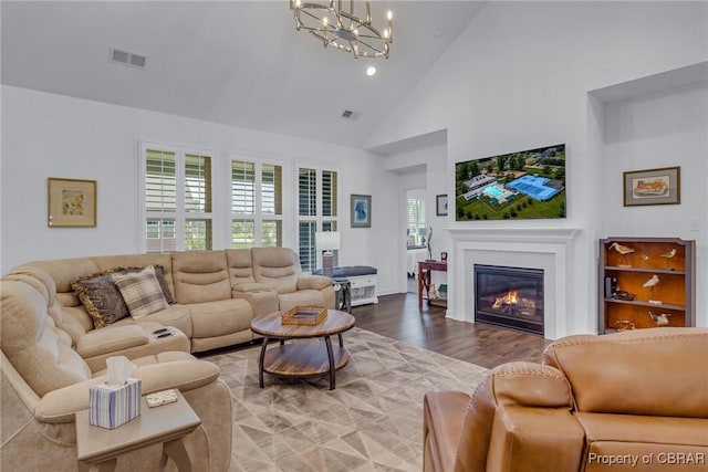 12 Essie Ct, Irvington, VA 22480 - living area featuring high vaulted ceiling, a glass covered fireplace, a chandelier, wood finished floors, and recessed lighting