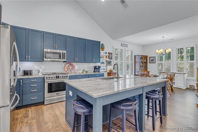 12 Essie Ct, Irvington, VA 22480 - kitchen with stainless steel appliances, blue cabinetry, a chandelier, a breakfast bar area, and high vaulted ceiling