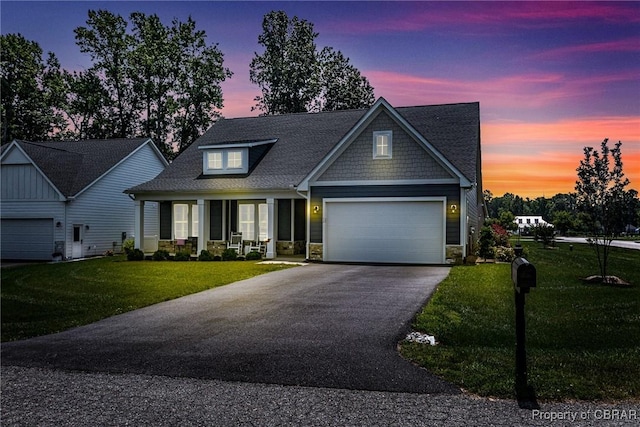 12 Essie Ct, Irvington, VA 22480 - craftsman house with asphalt driveway, an attached garage, a front lawn, stone siding, and covered porch