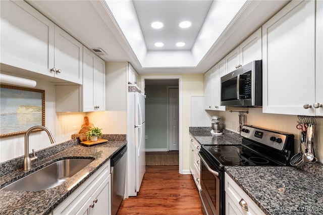 2956 Hathaway Rd Unit 807, Richmond, VA 23225 - kitchen with stainless steel appliances, wood finished floors, white cabinets, a tray ceiling, and dark stone counters