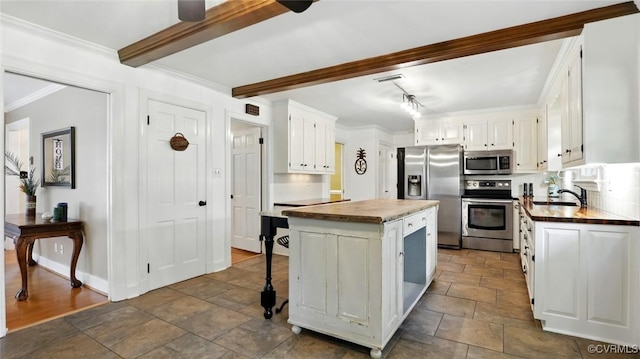 2711 Salisbury Rd, Midlothian, VA 23113 - kitchen with stainless steel appliances, stone tile flooring, a kitchen island, white cabinets, and crown molding
