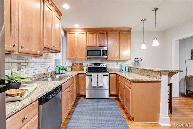 619 Roseneath Rd Unit U21, Richmond, VA 23221 - kitchen featuring stainless steel appliances, a peninsula, a kitchen bar, backsplash, and recessed lighting
