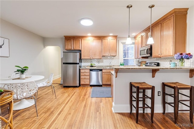 619 Roseneath Rd Unit U21, Richmond, VA 23221 - kitchen featuring appliances with stainless steel finishes, light wood-style floors, a breakfast bar area, tasteful backsplash, and recessed lighting