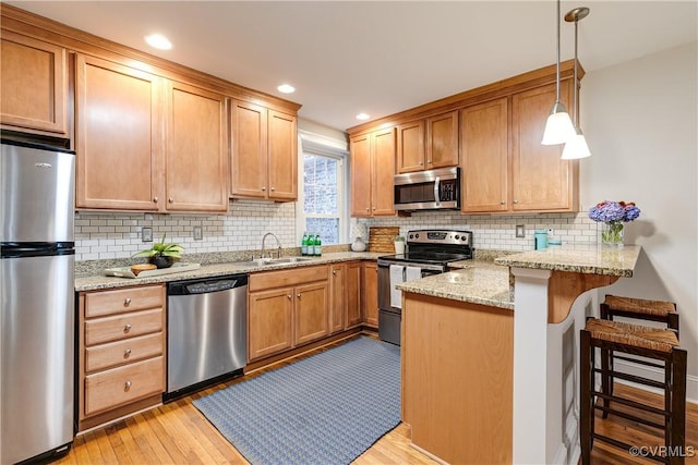 619 Roseneath Rd Unit U21, Richmond, VA 23221 - kitchen with stainless steel appliances, a peninsula, light wood-style floors, decorative backsplash, and recessed lighting