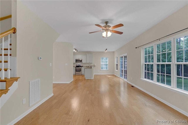 8619 Thomas Jefferson Way, Gloucester, VA 23061 - unfurnished living room featuring light wood-type flooring, stairway, and a ceiling fan