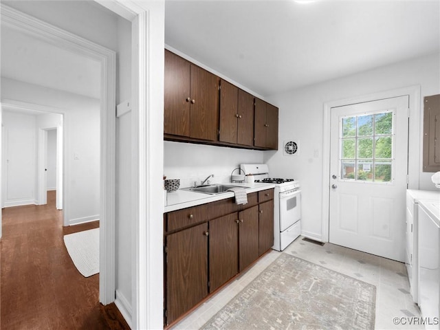 1627 Skipwith Rd, Henrico, VA 23229 - kitchen featuring white gas stove, independent washer and dryer, light countertops, and dark brown cabinetry