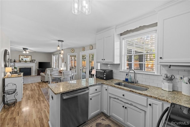 11830 Explorer Ct, Midlothian, VA 23114 - kitchen featuring dishwasher, a fireplace, a peninsula, tasteful backsplash, and white cabinetry