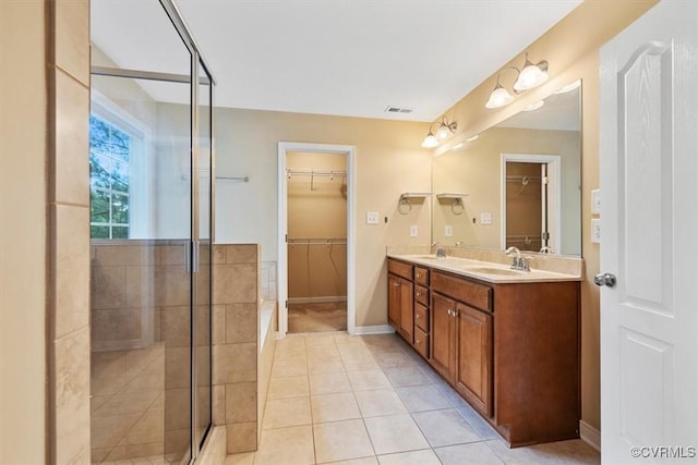 8738 New Holland Ln, Mechanicsville, VA 23116 - bathroom featuring a stall shower, a spacious closet, double vanity, and tile patterned flooring