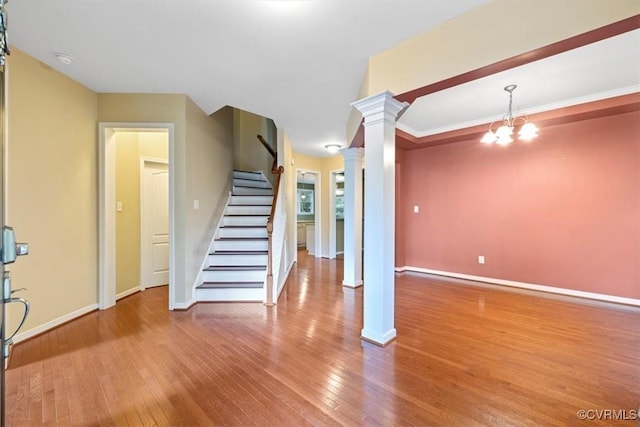 8738 New Holland Ln, Mechanicsville, VA 23116 - stairway with ornate columns, hardwood / wood-style floors, and a chandelier