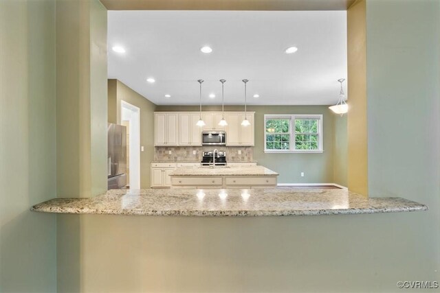 8738 New Holland Ln, Mechanicsville, VA 23116 - kitchen with appliances with stainless steel finishes, a peninsula, backsplash, light stone counters, and recessed lighting