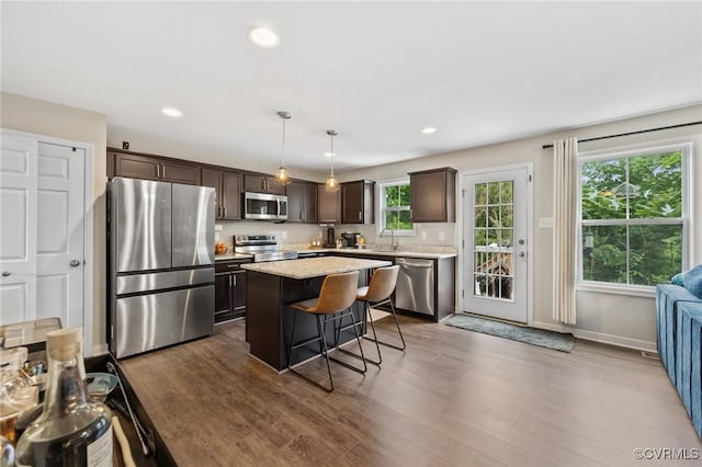 7318 Lancewood Ct, Chesterfield, VA 23832 - kitchen featuring stainless steel appliances, dark brown cabinetry, a breakfast bar, dark wood-type flooring, and recessed lighting