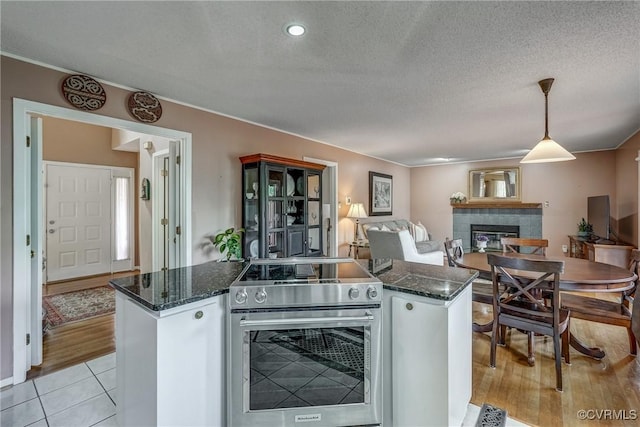 2711 Robson Ct, Henrico, VA 23233 - kitchen featuring stainless steel range with electric cooktop, a fireplace, open floor plan, a kitchen island, and a textured ceiling