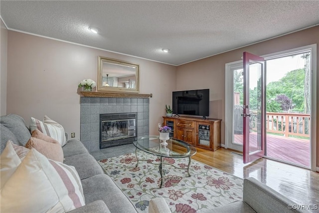 2711 Robson Ct, Henrico, VA 23233 - living room with a tile fireplace, a textured ceiling, ornamental molding, wood finished floors, and recessed lighting