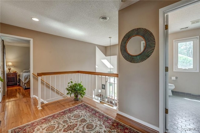 2711 Robson Ct, Henrico, VA 23233 - hallway with a textured ceiling, wood finished floors, and an upstairs landing