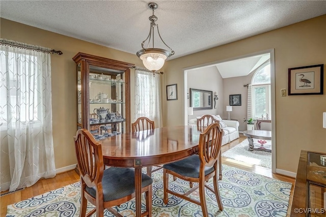 2711 Robson Ct, Henrico, VA 23233 - dining area featuring healthy amount of natural light, light wood-style flooring, a textured ceiling, and lofted ceiling