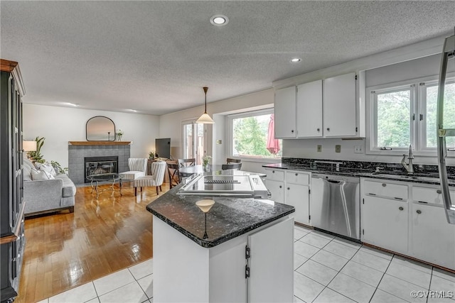 2711 Robson Ct, Henrico, VA 23233 - kitchen with stainless steel dishwasher, a center island, a tile fireplace, white cabinetry, and open floor plan