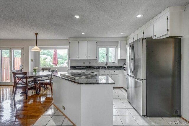 2711 Robson Ct, Henrico, VA 23233 - kitchen featuring freestanding refrigerator, black electric stovetop, a textured ceiling, a kitchen island, and white cabinetry